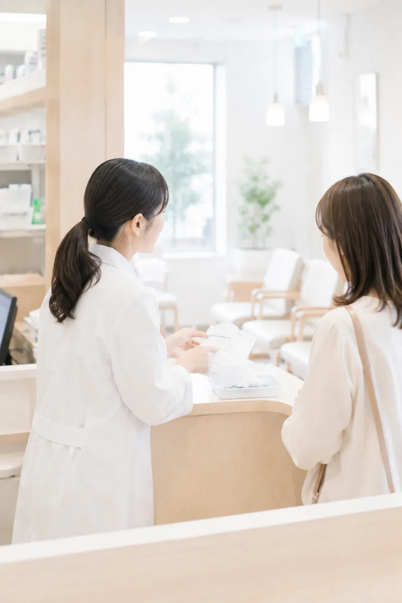 投薬カウンターで説明する薬剤師